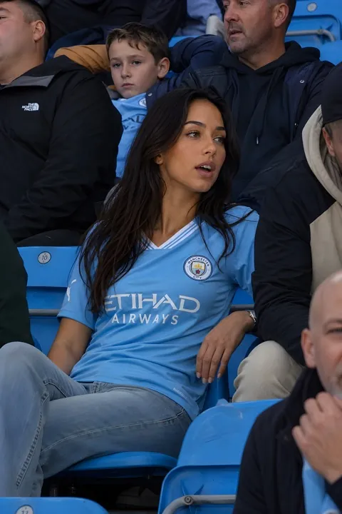 Image IA — supportrice en tribune de stade